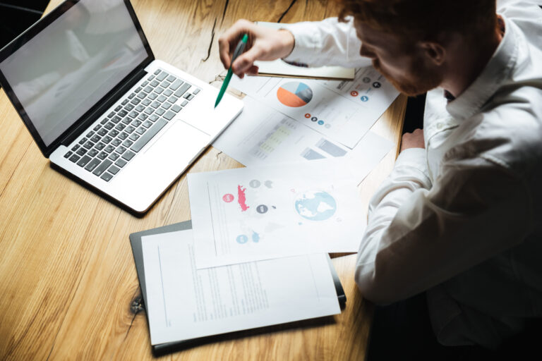 Top view of young successful businessman in white shirt working
